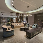 Cream Curved Sofa with Diamond-Quilted Backrest, Dark High-Gloss Sides and Teal Accent Panels